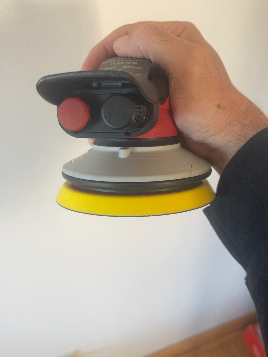 Actual Universal Tool orbital sander held in hand, rear control and grip view
